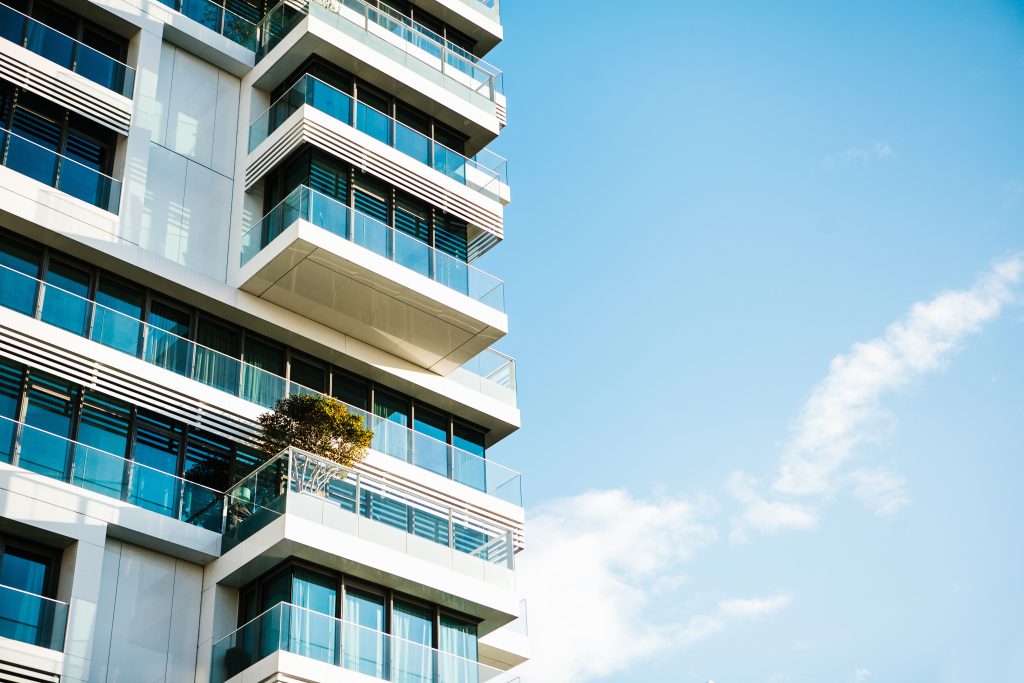 The corner of the building with many windows against the blue sky; condo property tax case study