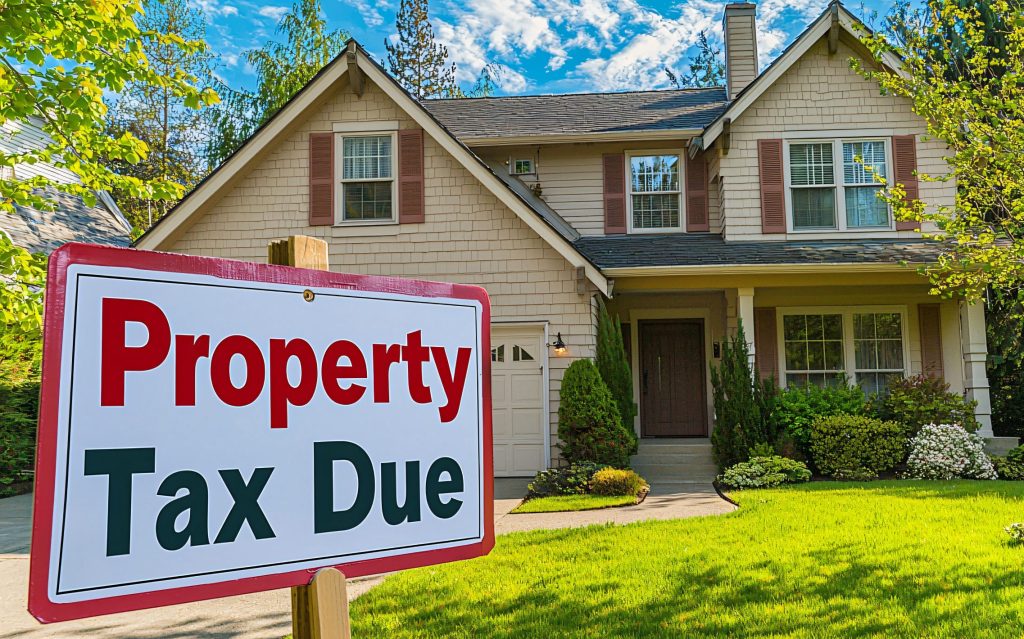 A family home with a "Property Tax Due" sign on the front lawn, emphasizing what you need to know about your Texas property tax bill